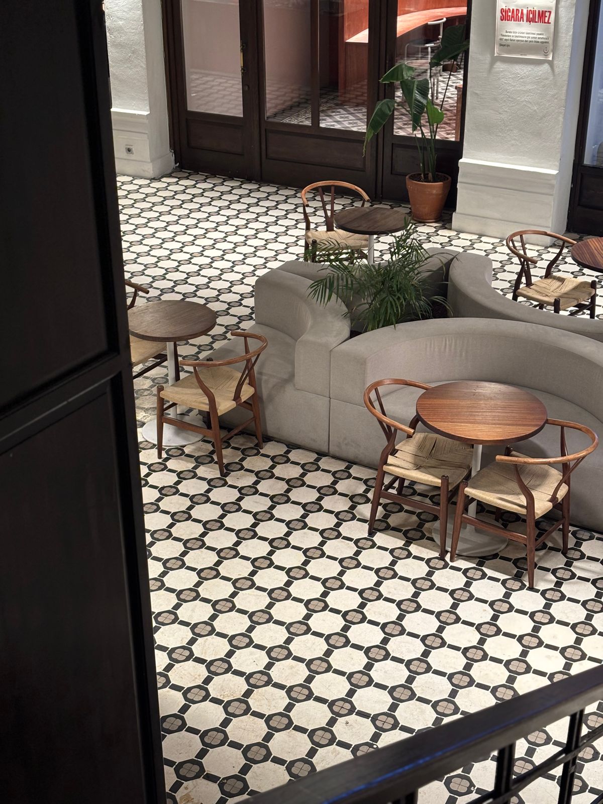 Café seating with warm wooden furniture and a patterned tiled floor